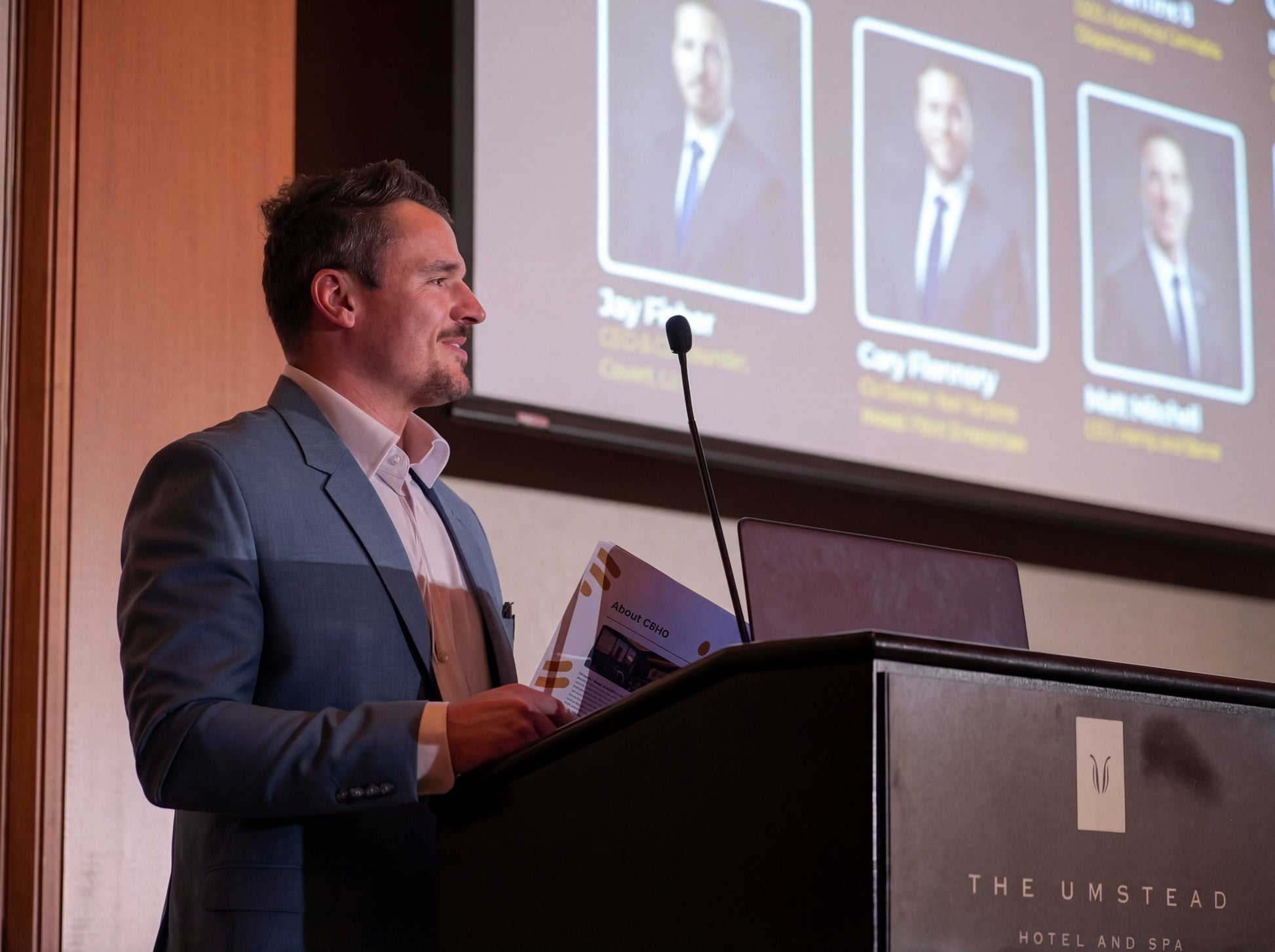 Dustin Brauns in suit presenting at CBHD legislative summit with presentation slides